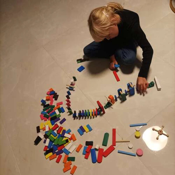 Jeu de dominos en bois illustrant une réaction en chaîne
